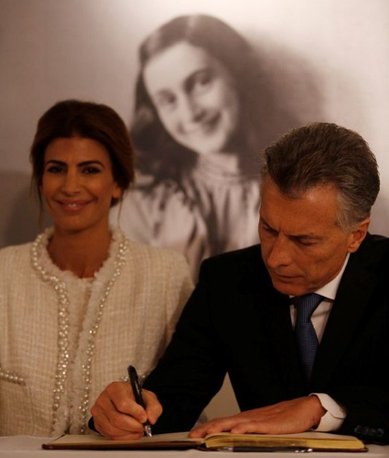 Argentina's President Mauricio Macri and his wife Juliana Awada sign the guest book as they sit in front of an image of Anne Frank during a visit to the Anne Frank House in Amsterdam, Netherlands - Argentina's President Mauricio Macri and his wife Juliana Awada sign the guest book as they sit in front of an image of Anne Frank during a visit to the Anne Frank House in Amsterdam, Netherlands, March 27, 2017. REUTERS/Cris Toala Olivares