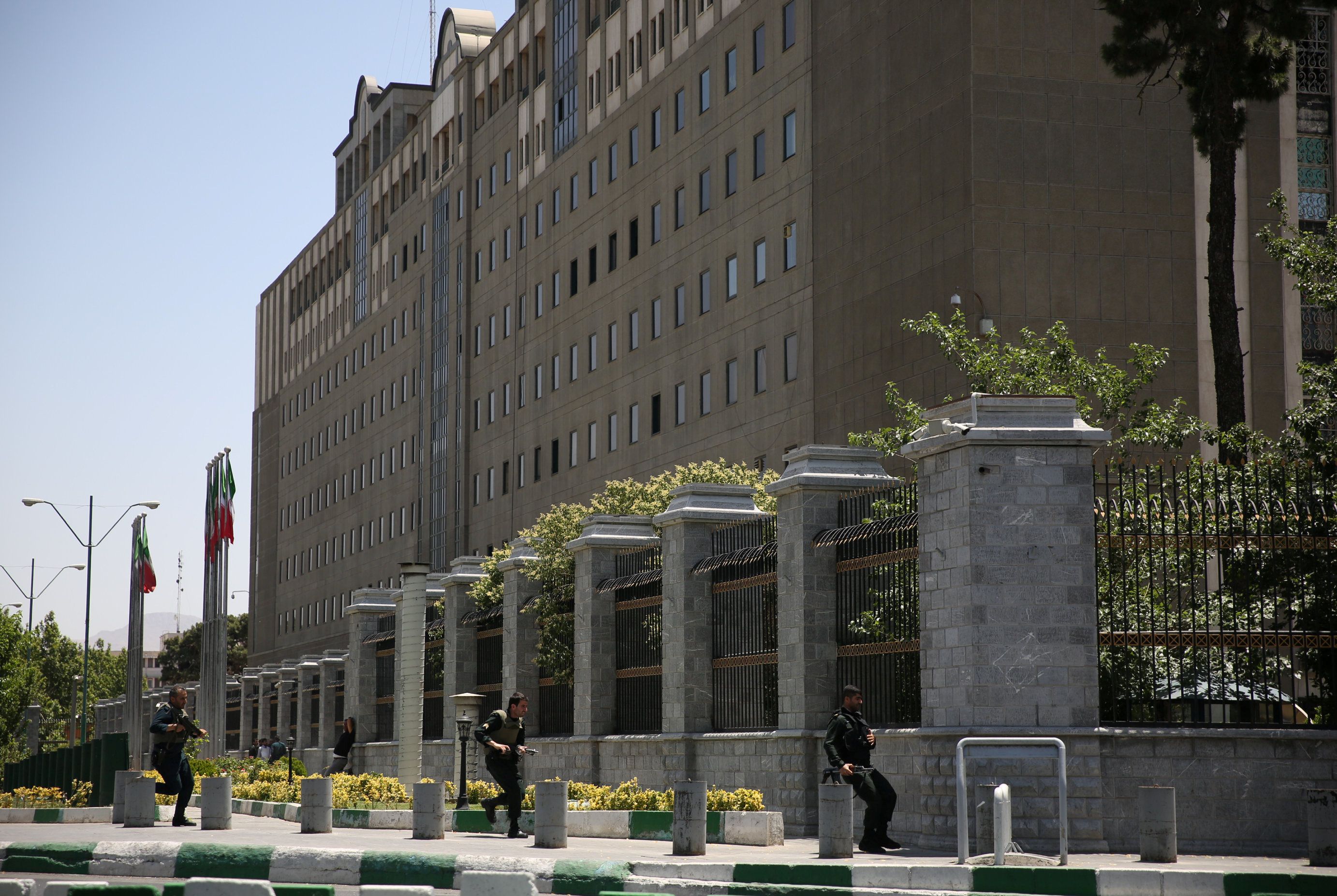 Members of Iranian forces run during a gunmen attack at the parliament's building in central Tehran - EUO 3TP