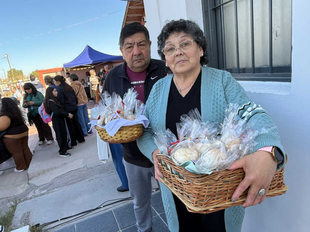 Griselda Tivani y Román Bustos repartieron panes y estampitas de San Cayetano entre los fieles para agradecer por las bendiciones recibidas. 'Hoy también agradecemos por la visita del Papa y rezamos para que traiga bendiciones para todos los argentinos', dijo Griselda.