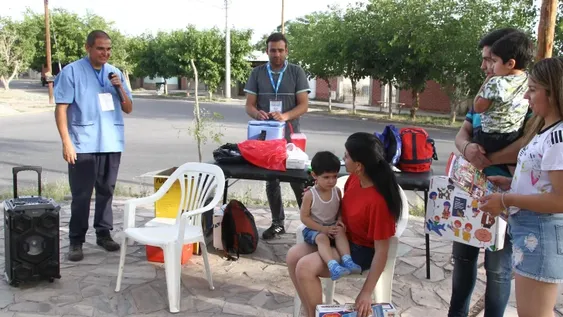 El personal sanitario que utiliza un parlante para invitar a los vecinos a que vacunen a sus hijos