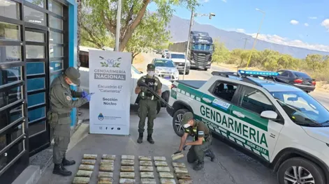 Gendarmes junto a la droga incautada.