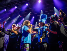 La Mona Jiménez y los jugadores de Belgrano celebran con euforia en el escenario. La Mona Jiménez y los jugadores de Belgrano celebran con euforia en el escenario.