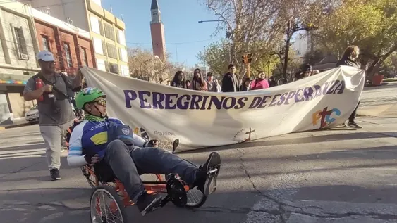 Germán Aballay marcha al frente de la peregrinación de jóvenes en su triciclo adaptado.