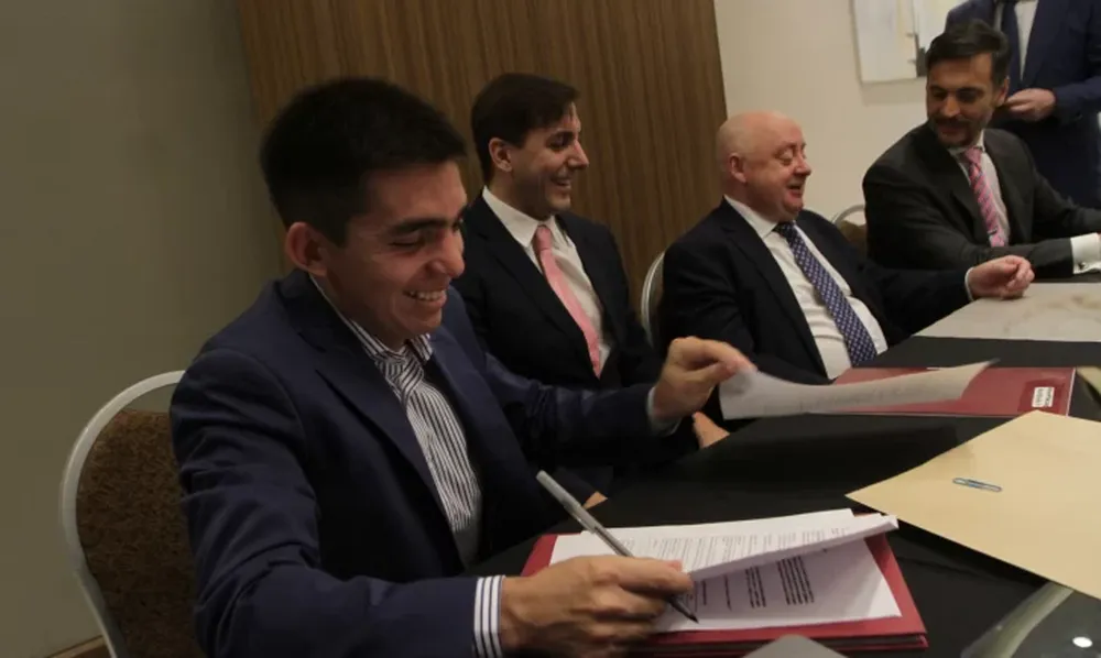 La firma. En la imagen, Sebastián Lobo, Francisco Pontoriero, Paul Stanley y Nicolás Avellaneda, mientras firmaban la venta el pasado viernes. El CEO de Achilles viajó a San Juan especialmente para el momento.