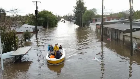 UN RÍO. La punta de la parte trasera un auto asomando bajo el agua -a la derecha de la foto- muestra el nivel de las aguas.