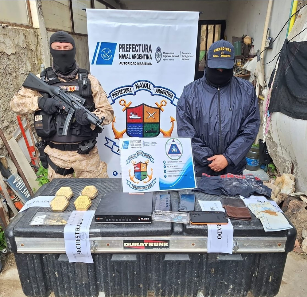 Efectivos de Prefectura Naval Argentina exhibieron los cuatro lingotes de oro y otros elementos secuestrados durante los allanamientos realizados en Caleta Olivia, Santa Cruz.