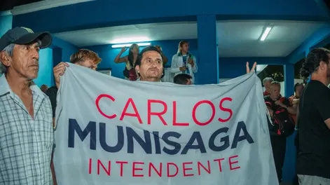 Un militante sostiene la bandera de Carlos Munisaga en la sede del PJ San Juan.-