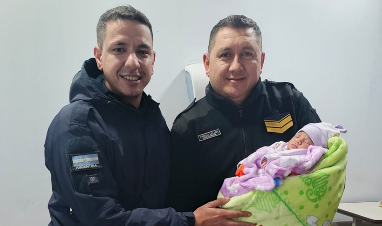 Los efectivos policiales que ayudaron en el parto junto a la pequeña recién nacida.