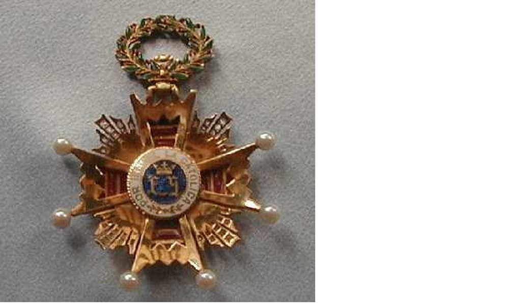 La ilustre distinción de 65 mm de altura, que han recibido todas, consiste en una cruz de oro macizo de 53 mm de diámetro que pende de una corona oval de laureles esmaltados con cuatro brazos iguales y simétricos terminados en ocho puntas.