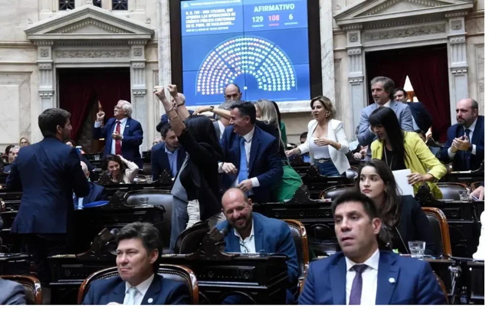 PUÑOS EN ALTO. Diputados libertarios festejan la votación que blindó el acuerdo con el FMI tras una sesión caliente con gritos e insultos de los legisladores.