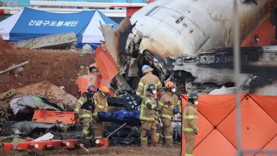 INFIERNO. Bomberos coreanos rescataban los restos carbonizados de los pasajeros y tripulantes fallecidos durante el siniestro en el aeropuerto internacional de Muan.