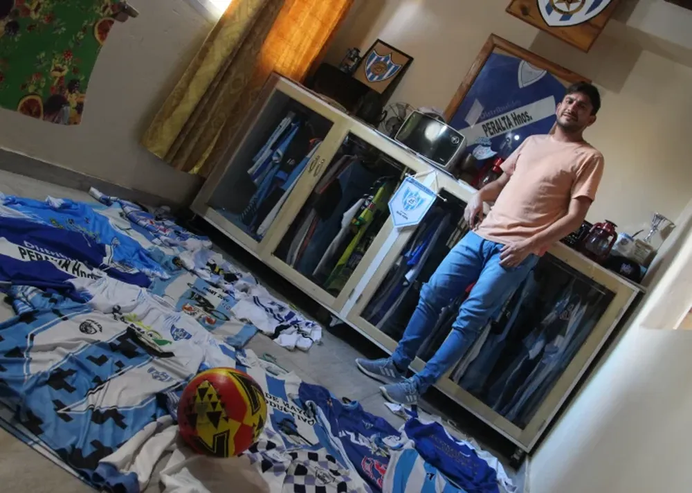 Amor por los colores. Saul Cortez, junto al museo que armó en el quincho de su casa en honor a Sportivo 25 de Mayo: camisetas, recuerdos y mucha pasión veinticinqueña.