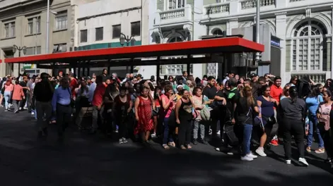 Varias personas permanecen en el exterior de edificios tras el apagón que afectó a gran parte del país, en Santiago.