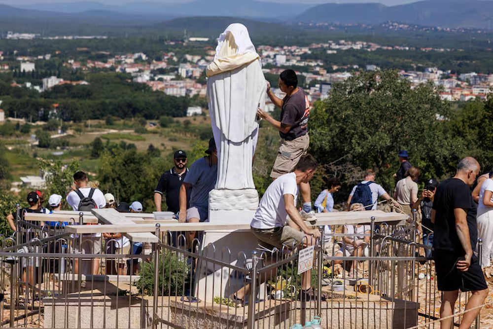 Voluntarios limpian la estatua vandalizada de la Virgen Mar&iacute;a, cubierta con una s&aacute;bana blanca, en la Colina de las Apariciones, en Medjugorje, BosniaAP Photo - AP