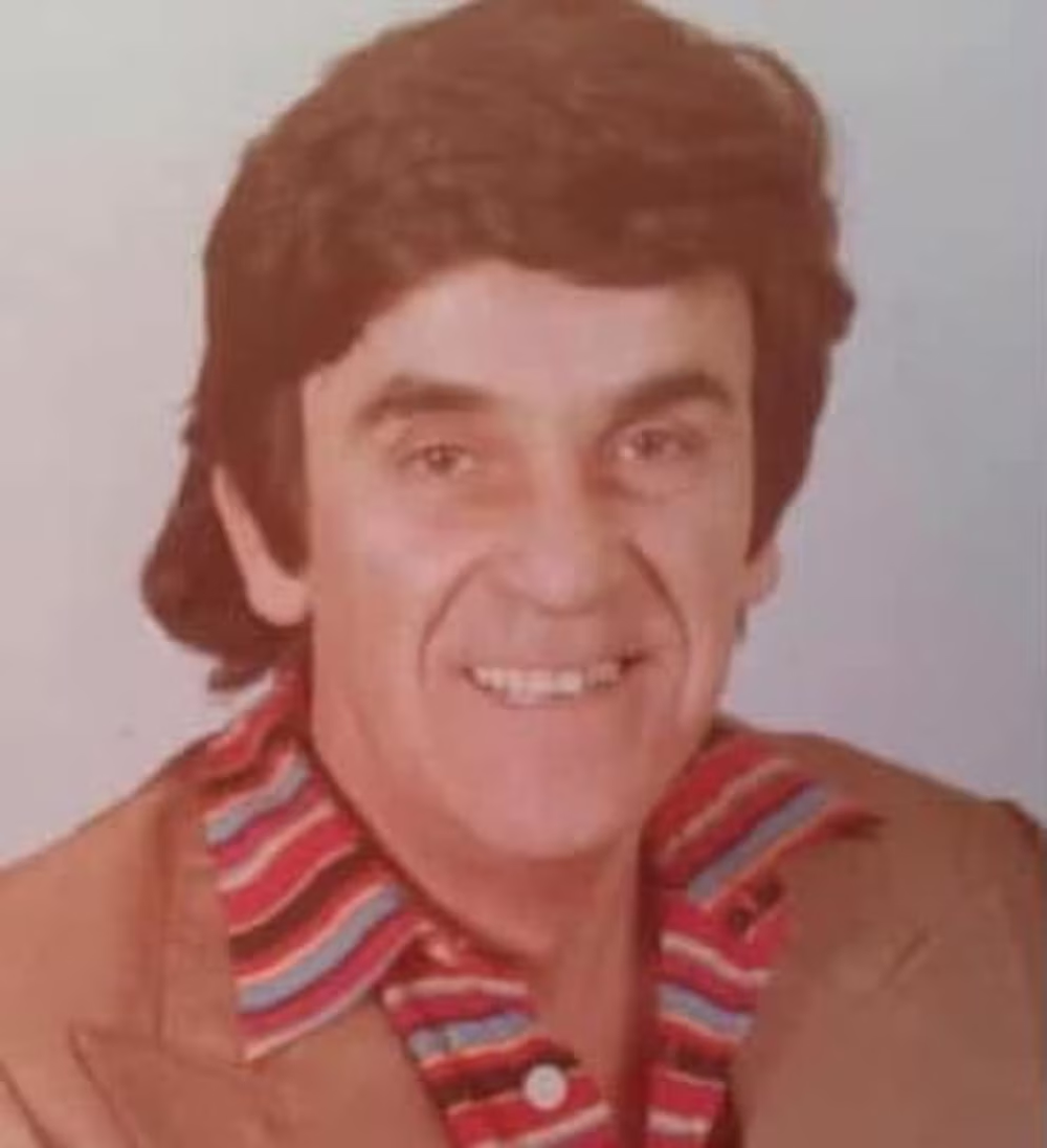Beto Cabrera posa sonriente en un retrato fotográfico de medio cuerpo, con el cabello castaño peinado hacia atrás y una camisa a rayas.
