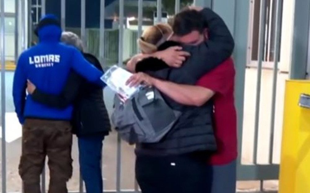 EMOCIÓN. Dos de los argentinos deportados se abrazan a un familiar tras la llegada del vuelo al aeropuerto de Ezeiza.