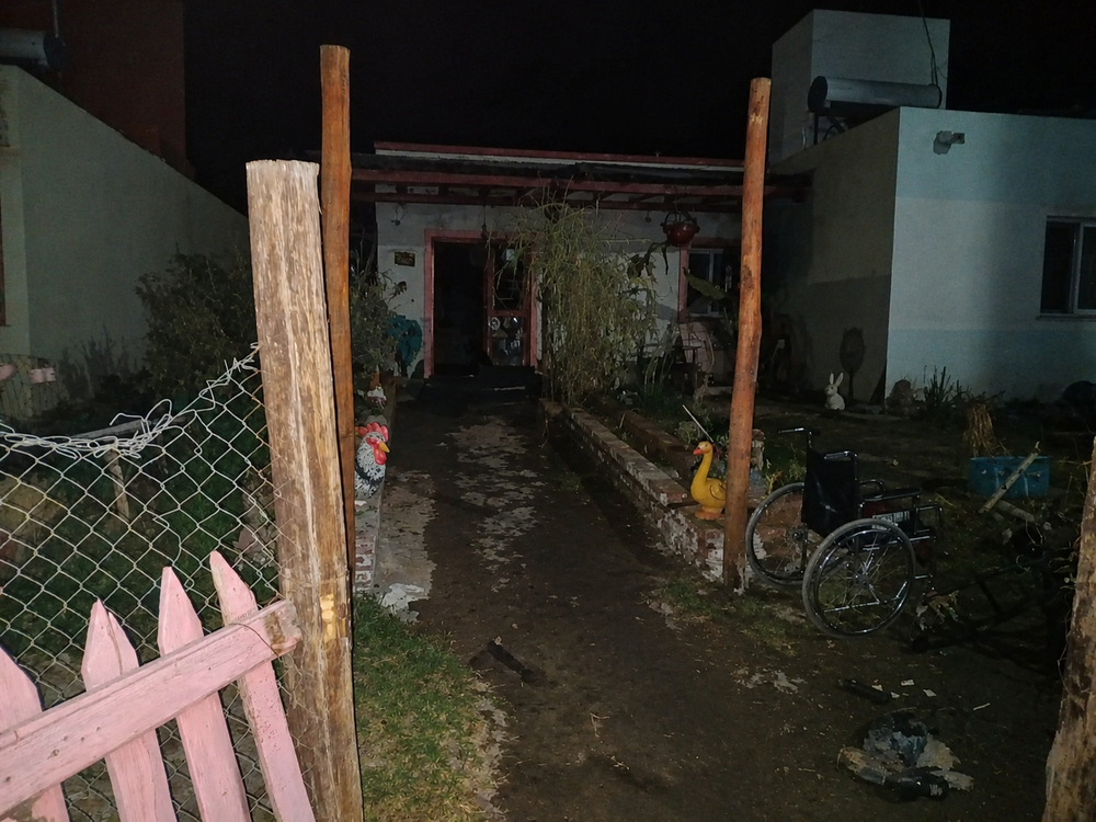 El frente de la casa incendiada. En la imagen se puede ver una silla de ruedas, que era usada por una de las víctimas.&nbsp;