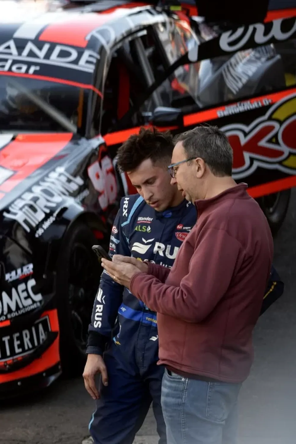 Tobías junto a los ingenieros de su equipo analizando el rendimiento de su auto.