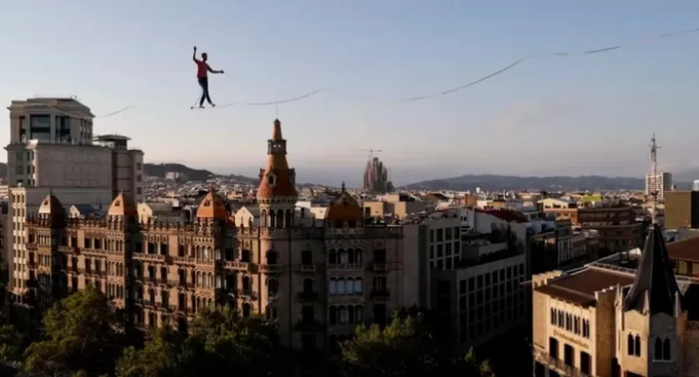 A 70 metros de altura, descalzo y sobre una cuerda metálica, un equilibrista impresionó a todos en Barcelona
