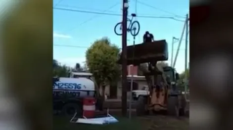 Utiliza una pala mecánica para colgar su bici en un poste de luz y que no se la roben