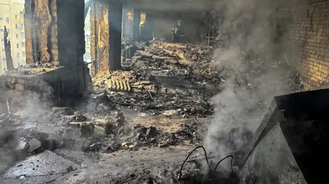 Bomberos trabajan en un edificio de apartamentos alcanzado por un dron ruso, en medio del ataque contra Ucrania.