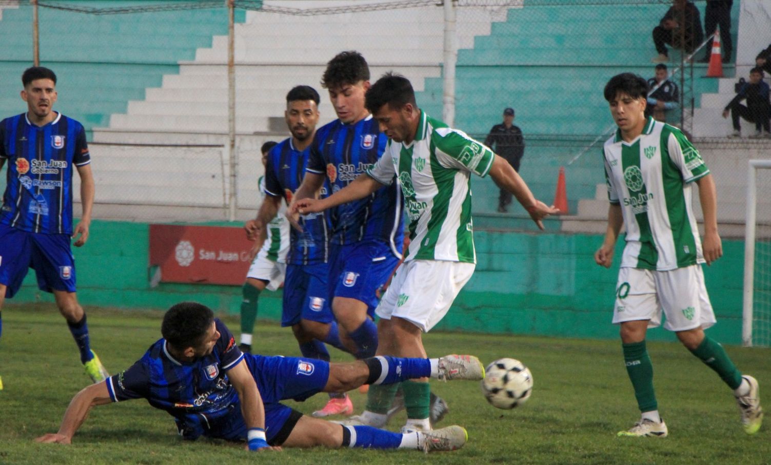 Al piso. Oballes, de Unión, traba la salida de Aguirre, el volante central de Sportivo. En Puyuta, mano a mano en un intenso debut de los equipos de San Juan en el Regional Amateur. Foto: Daniel Arias.
