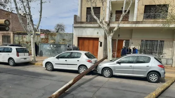 Dos enormes postes de madera cayeron de un camión e impactaron con autos estacionados