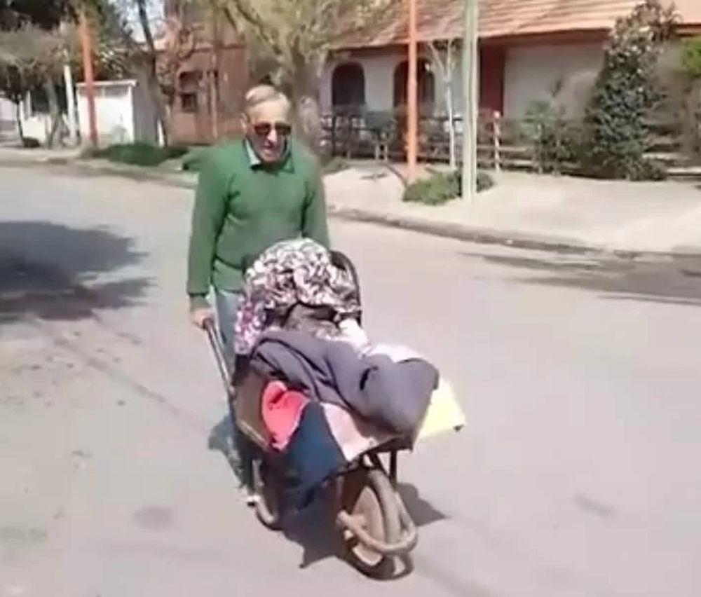 Un abuelo lleva en carretilla a su nieta al jardín y se volvió viral