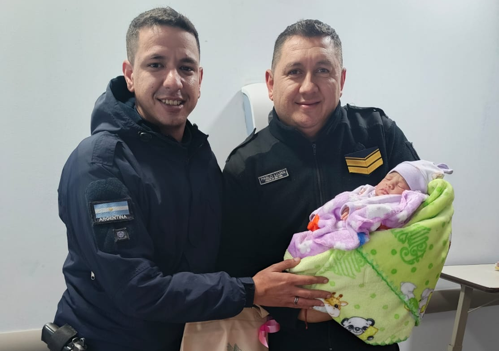 Los efectivos policiales que ayudaron en el parto junto a la pequeña recién nacida.