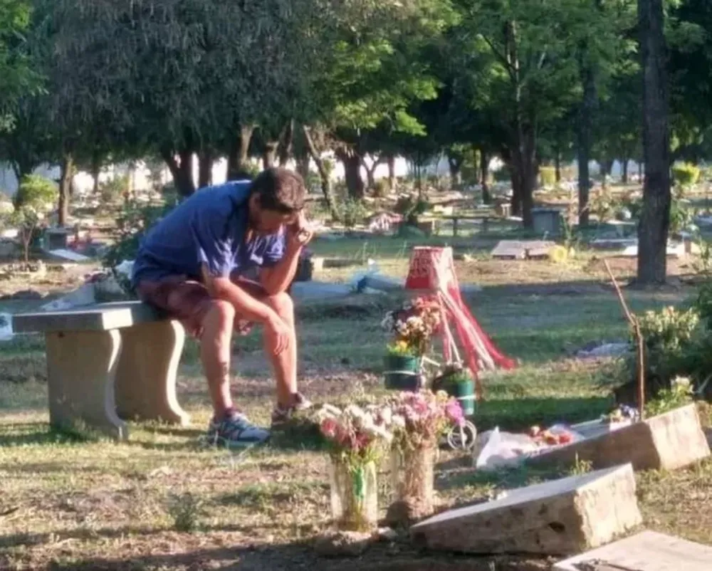 Una papá escucha los partidos de San Martín de Tucumán en la tumba de su hijo