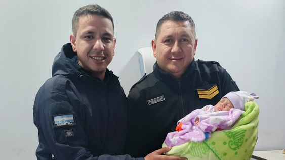 Los efectivos policiales que ayudaron en el parto junto a la pequeña recién nacida.