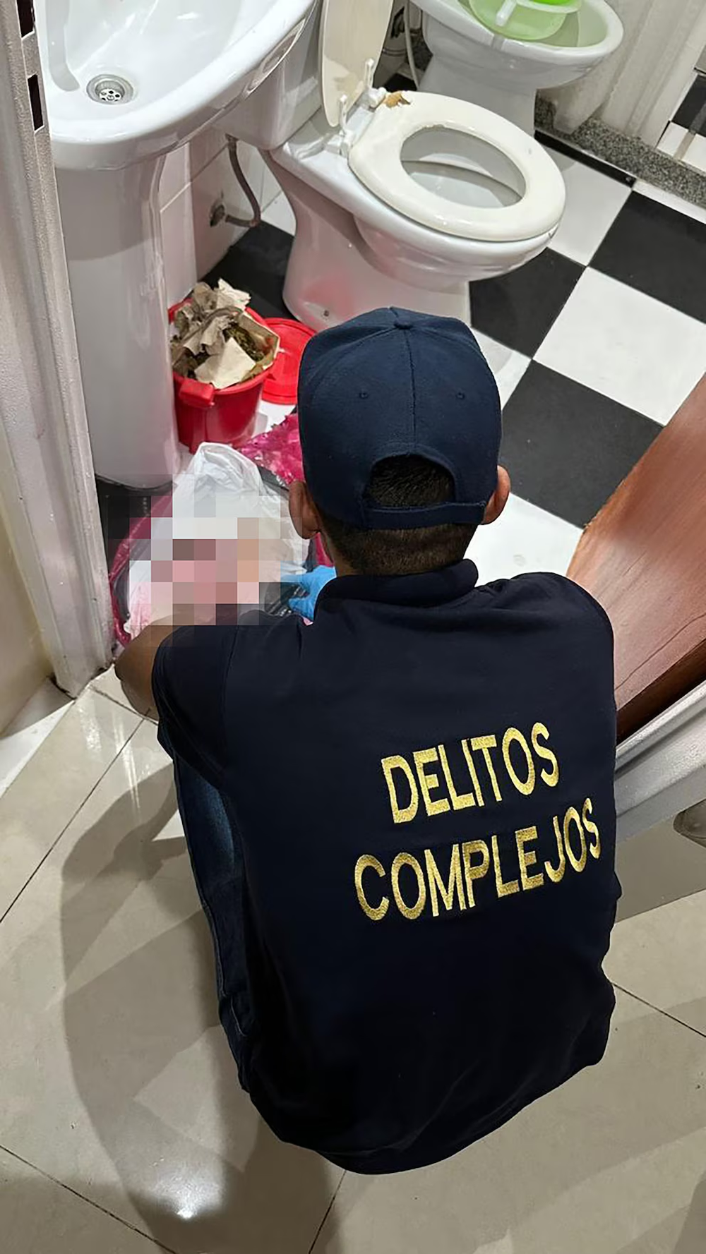 Un agente de Delitos Complejos examina un baño tras el hallazgo de fetos en una clínica de Villa Ballester.
