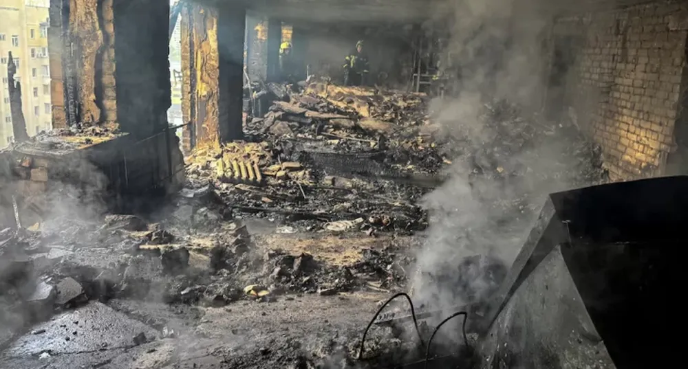 Bomberos trabajan en un edificio de apartamentos alcanzado por un dron ruso, en medio del ataque contra Ucrania.