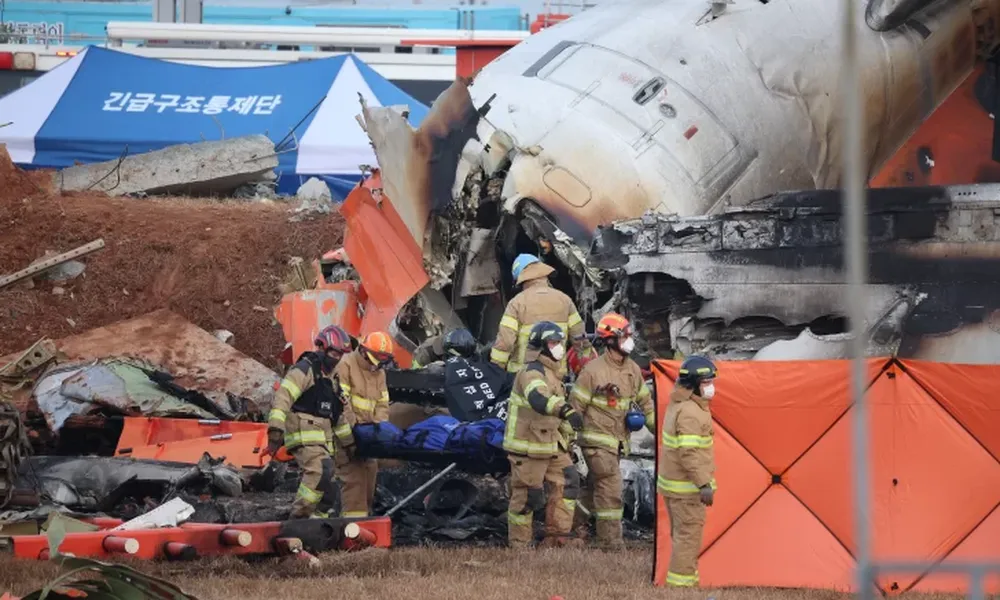 INFIERNO. Bomberos coreanos rescataban los restos carbonizados de los pasajeros y tripulantes fallecidos durante el siniestro en el aeropuerto internacional de Muan.
